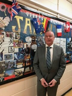 john next to notice board